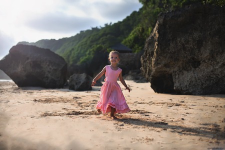 Beautiful little girl at the beach. Sunblock cream for children.の写真素材