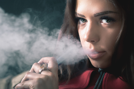 Young, beautiful girl smoke a hookah at club