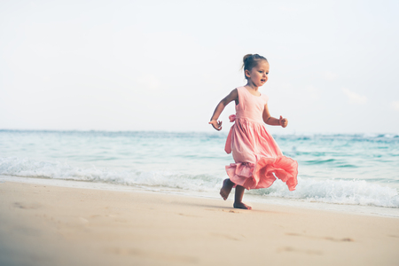 Beautiful little girl at the beach. Sunblock cream for children.の写真素材