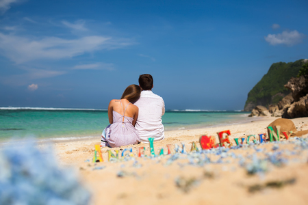 Portrait of Happy Couple, sits on beach with Sea Viewの写真素材