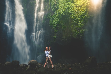 Amazing romantic view of happy couple near beautiful grand waterfallの写真素材