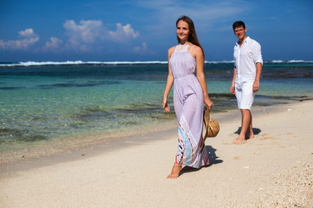 Wedding couple just married holds hands and walking at beachの写真素材