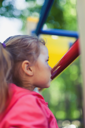 Climbing little girl at playground. Playground outdoor in summer timeの写真素材