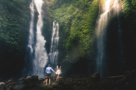 Amazing romantic view of happy couple near beautiful grand waterfallの写真素材