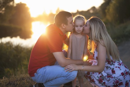 Mom and dad hold their daughter hands. Happy successful family.の写真素材
