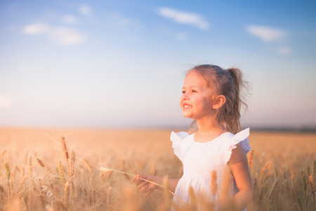 Happy Little Girl Outdoor At Wheat Field. End of Summerの写真素材