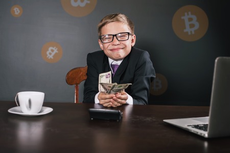 Successfully boy earning money with bitcoin cryptocurrency.の写真素材