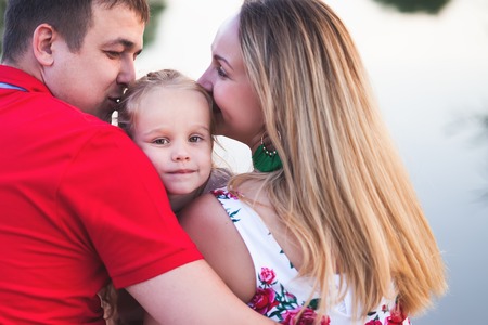 Mom and dad hold their daughter hands. Happy successful family.の写真素材