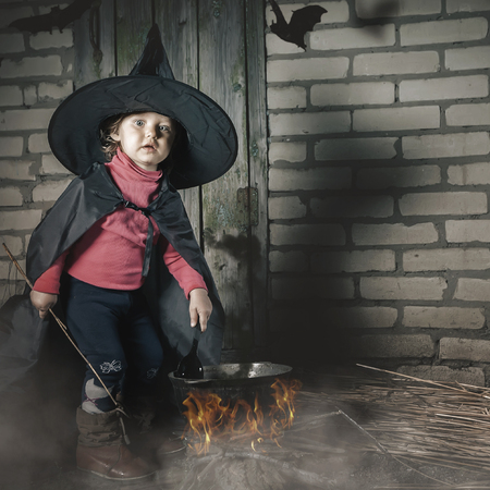 Little witch making a magic potion at Halloween night. Horror.の写真素材