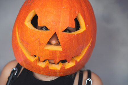 Woman with carved pumpkin on her head for Halloweenの写真素材