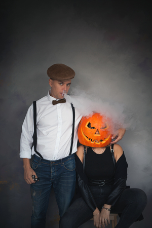 Woman with carved pumpkin on her head and manの写真素材