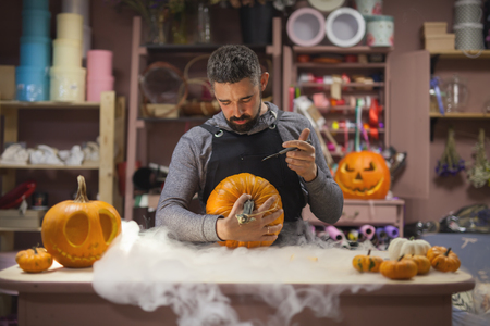 Man carves a pumpkin to decorate the Halloweenの写真素材