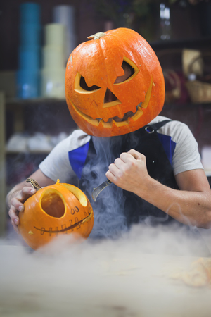 Man carves a pumpkin to decorate the Halloweenの写真素材
