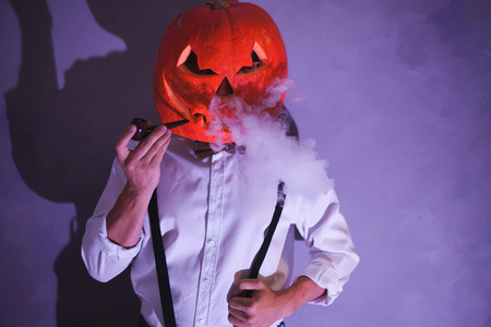 Handsome Man with carved pumpkin on his head for Halloweenの写真素材