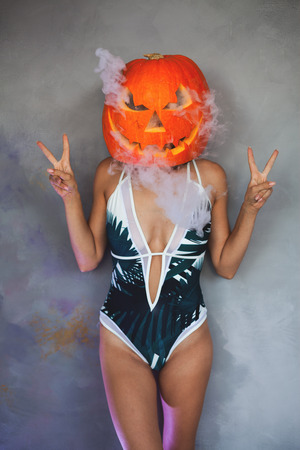 Sexy woman with carved pumpkin on her head for Halloweenの写真素材