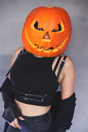 Woman with carved pumpkin on her head for Halloweenの写真素材