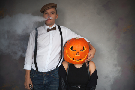 Unusual couple at Halloween party, Woman with pumpkin on headの写真素材