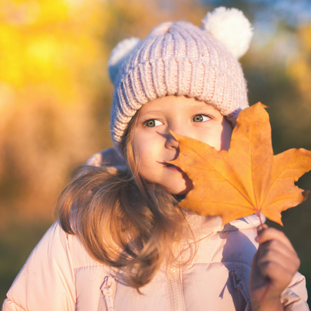Autumn outdoor portrait of girl holds leafの写真素材