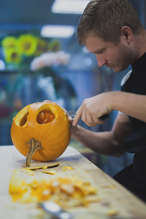 Man carves a pumpkin to decorate the Halloweenの写真素材