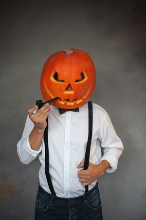 Handsome Man with carved pumpkin on his head for Halloweenの写真素材