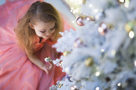 Little girl at Christmas decorating Christmas tree.の写真素材