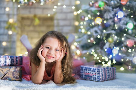 Happy child girl lies at her decorated kids room at Christmas nightの写真素材