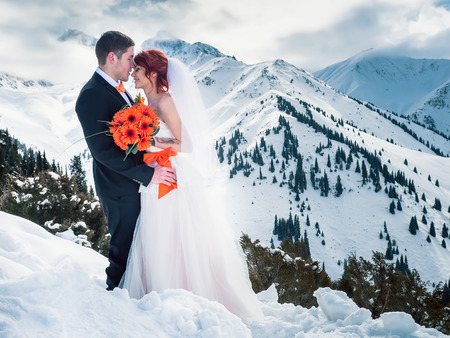Wedding snowboarders couple just married at mountain winterの写真素材