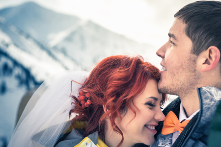 Wedding snowboarders couple just married at mountain winterの写真素材
