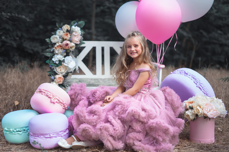 Cute little girl holds French Macaron. Confectionery conceptの写真素材