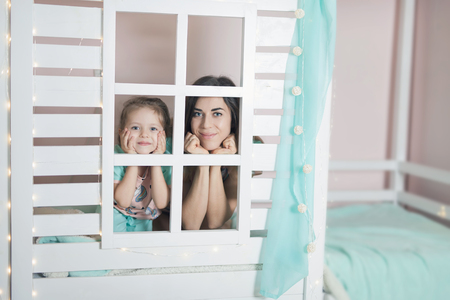 Happy mother and child preparing for sleep in children houseの写真素材