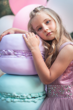 Cute little girl holds French Macaron. Confectionery conceptの写真素材