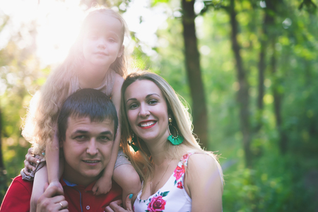 Mom and dad hold their daughter hands. Happy successful family.の写真素材