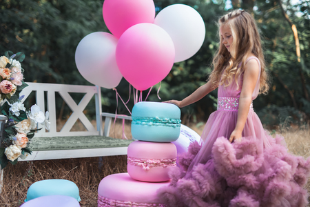 Cute little girl holds French Macaron. Confectionery conceptの写真素材