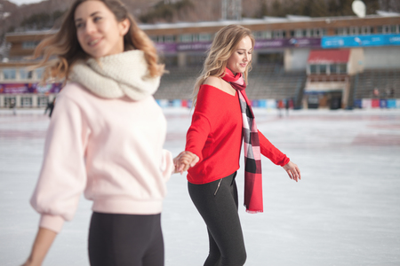 women ice skating outdoor at ice rinkの写真素材