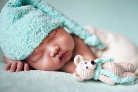 newborn baby asian boy sleeping at blue backgroundの写真素材