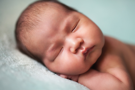 newborn baby asian boy sleeping at blue backgroundの写真素材