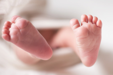 Mothercare newborn concept. Mother holding baby feetの写真素材