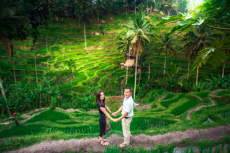 Happy couple walking at the rice terraces. Traveling at Bali.の写真素材