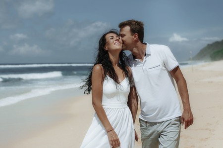 Happy couple walking at the beach, traveling at Bali.の写真素材