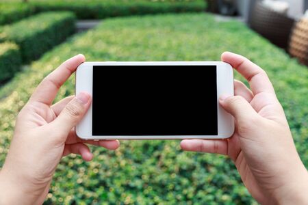 Close-up Of A Woman Hand Holding Cellphone Watching Videoの写真素材