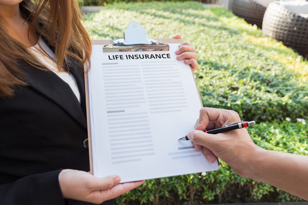Man signing the life insurance contract.の写真素材