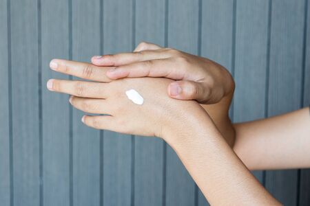 Young woman applying hands cream concept