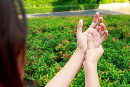 Asian woman hands pain in garden conceptの写真素材