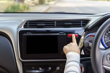woman finger pressing emergency button on car dashboard