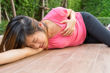 Sporty woman having heart attack at park- Angina Pectoris, Myocardial Infarctionの写真素材