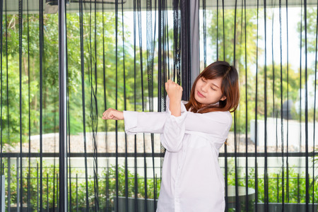 Woman stretching her arms while waking up at the morningの写真素材