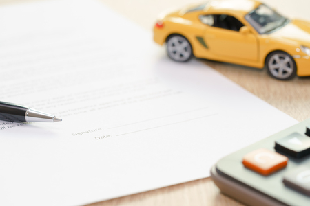 Pen pointing the place where should sign with car toy and calculator.の写真素材