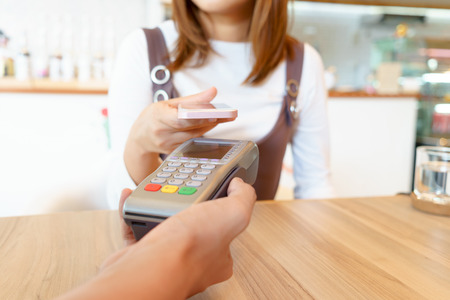 Woman paying money via smartphone with magnetic card conceptの写真素材