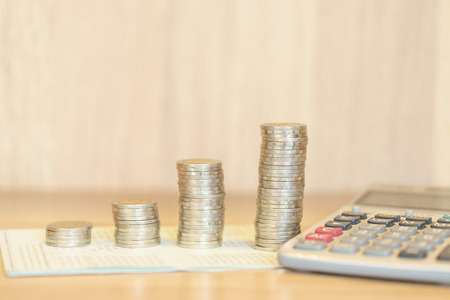 Stacked money for growing chart of coins with calculatorの写真素材