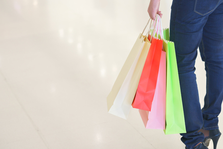 Close up of woman customer leg with colorful paper shopping bagsの写真素材